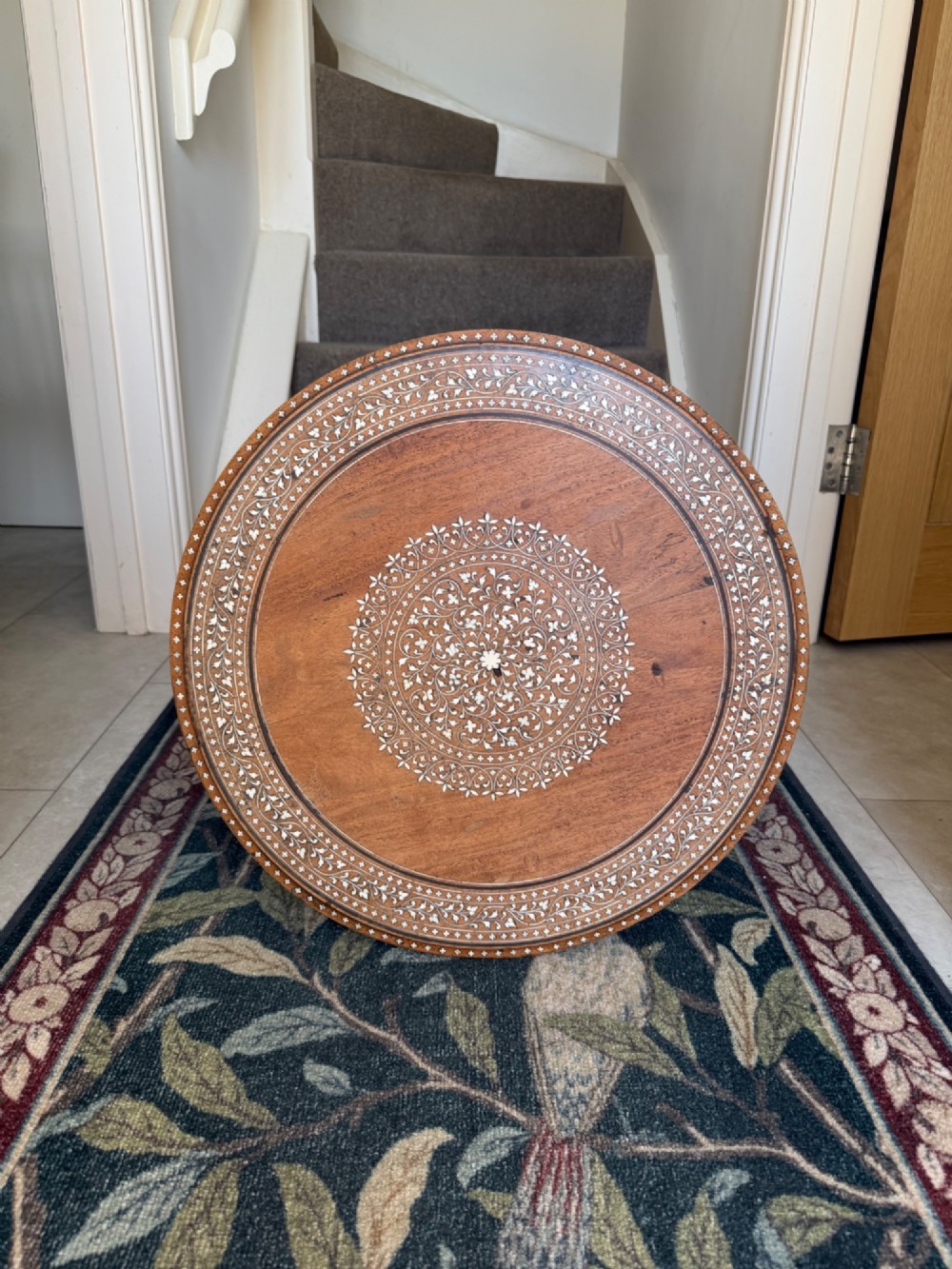 A circular dark wood Anglo-Indian pedestal table featuring intricate bone inlay patterns across the tabletop, turned central column, and tripod feet. View VI
