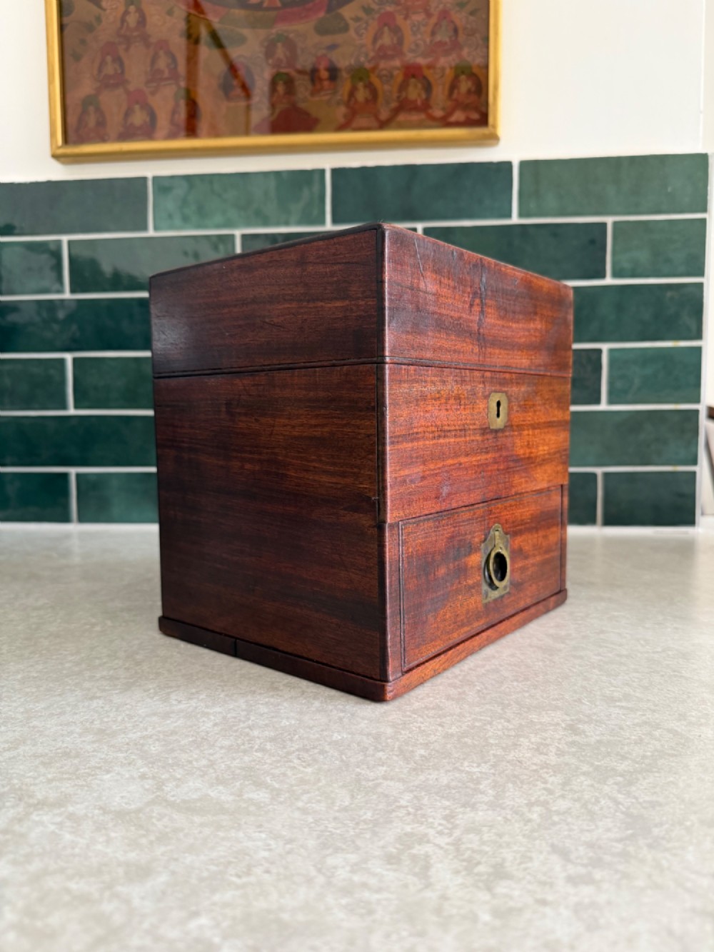 A rectangular 19th-century mahogany apothecary box featuring brass hardware, a flush top carrying handle, a keyhole, and a lower drawer. View V