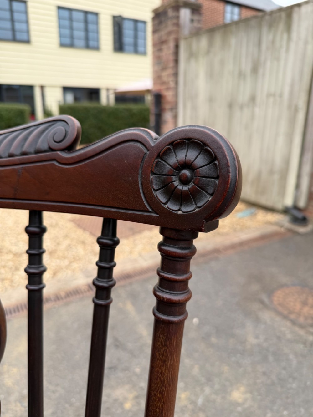 A carved dark mahogany armchair featuring cabriole front legs, turned spindles, a central shell back splat, and a shaped wooden seat. View II