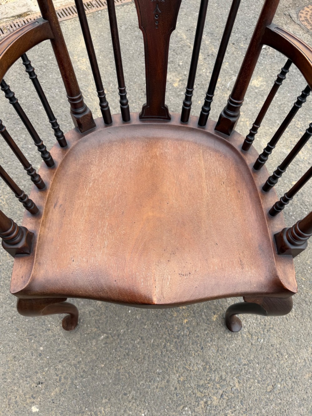 A carved dark mahogany armchair featuring cabriole front legs, turned spindles, a central shell back splat, and a shaped wooden seat. View III