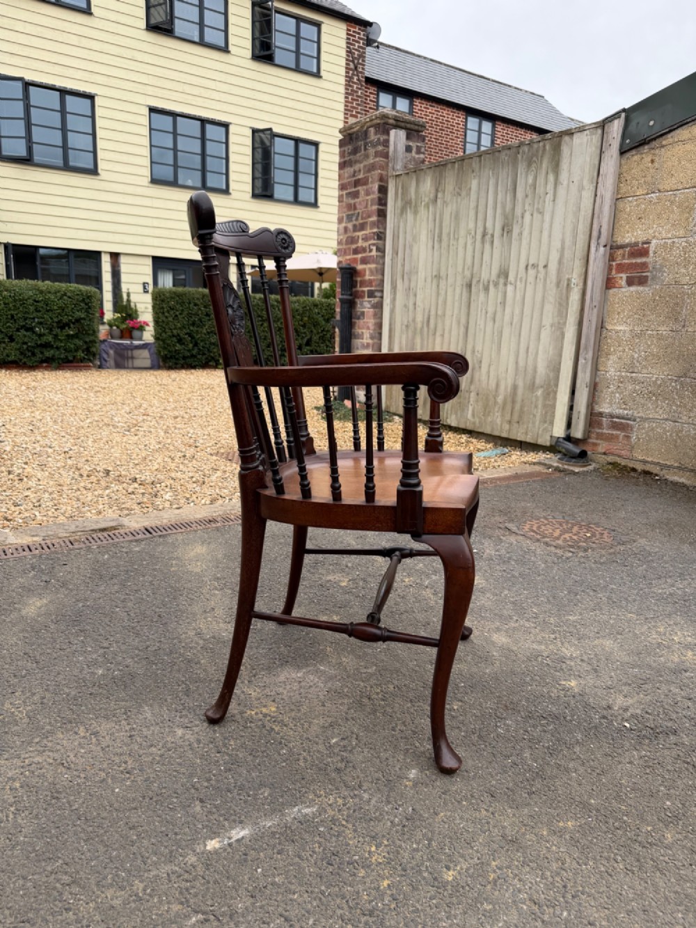 A carved dark mahogany armchair featuring cabriole front legs, turned spindles, a central shell back splat, and a shaped wooden seat. View IV