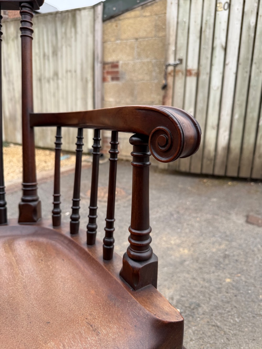 A carved dark mahogany armchair featuring cabriole front legs, turned spindles, a central shell back splat, and a shaped wooden seat. View V
