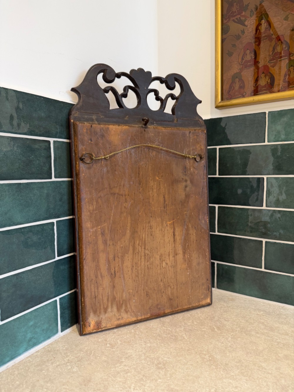 An antique Georgian mahogany wall mirror featuring a pierced fretwork cresting and a rectangular moulded frame with a foxed glass plate. View II