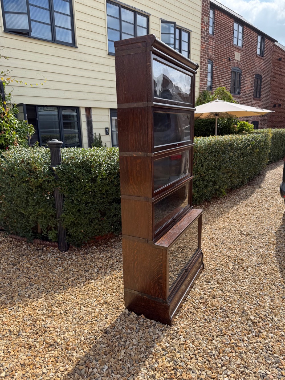 A five-tier dark oak Globe Wernicke sectional bookcase with up-and-over glazed glass doors. View V