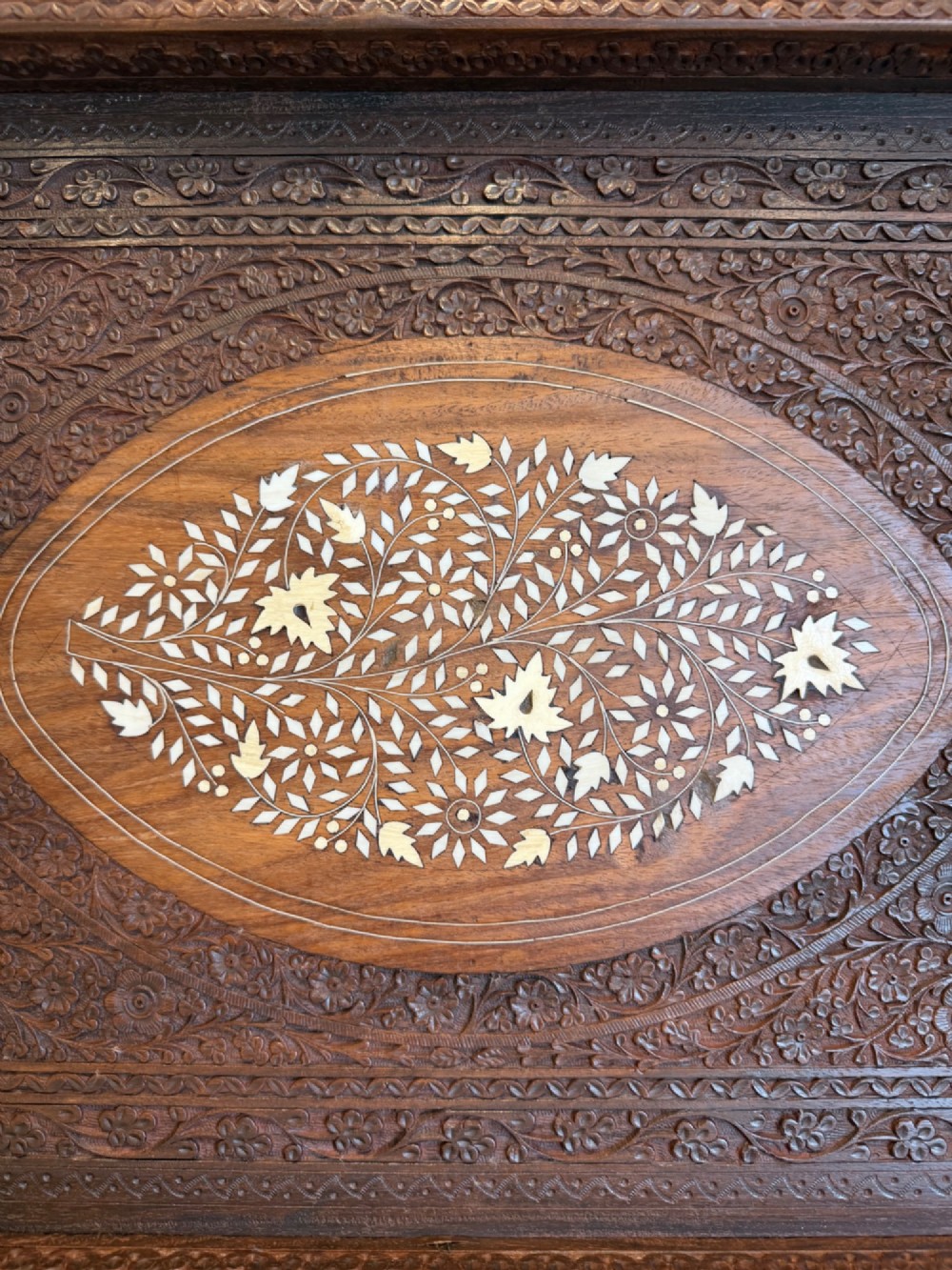 A rectangular dark walnut serving tray featuring intricate floral woodcarvings and a central oval medallion with delicate light-coloured inlay. View II