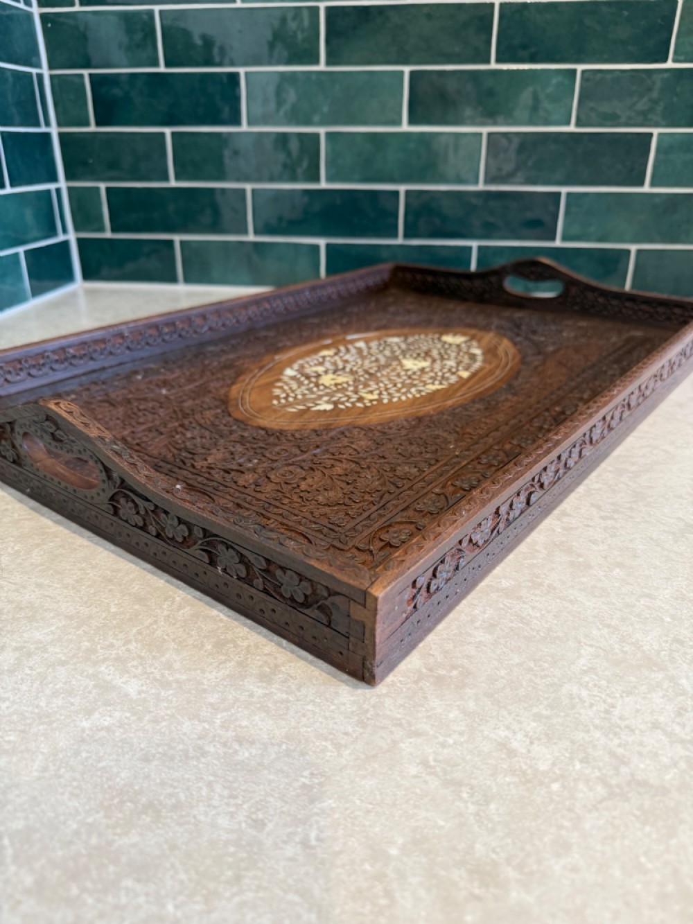 A rectangular dark walnut serving tray featuring intricate floral woodcarvings and a central oval medallion with delicate light-coloured inlay. View III