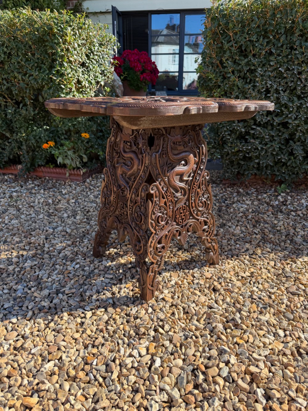 A hand-carved dark walnut side table featuring relief-carved dragon motifs across a lobed top and pierced decorative legs. View III