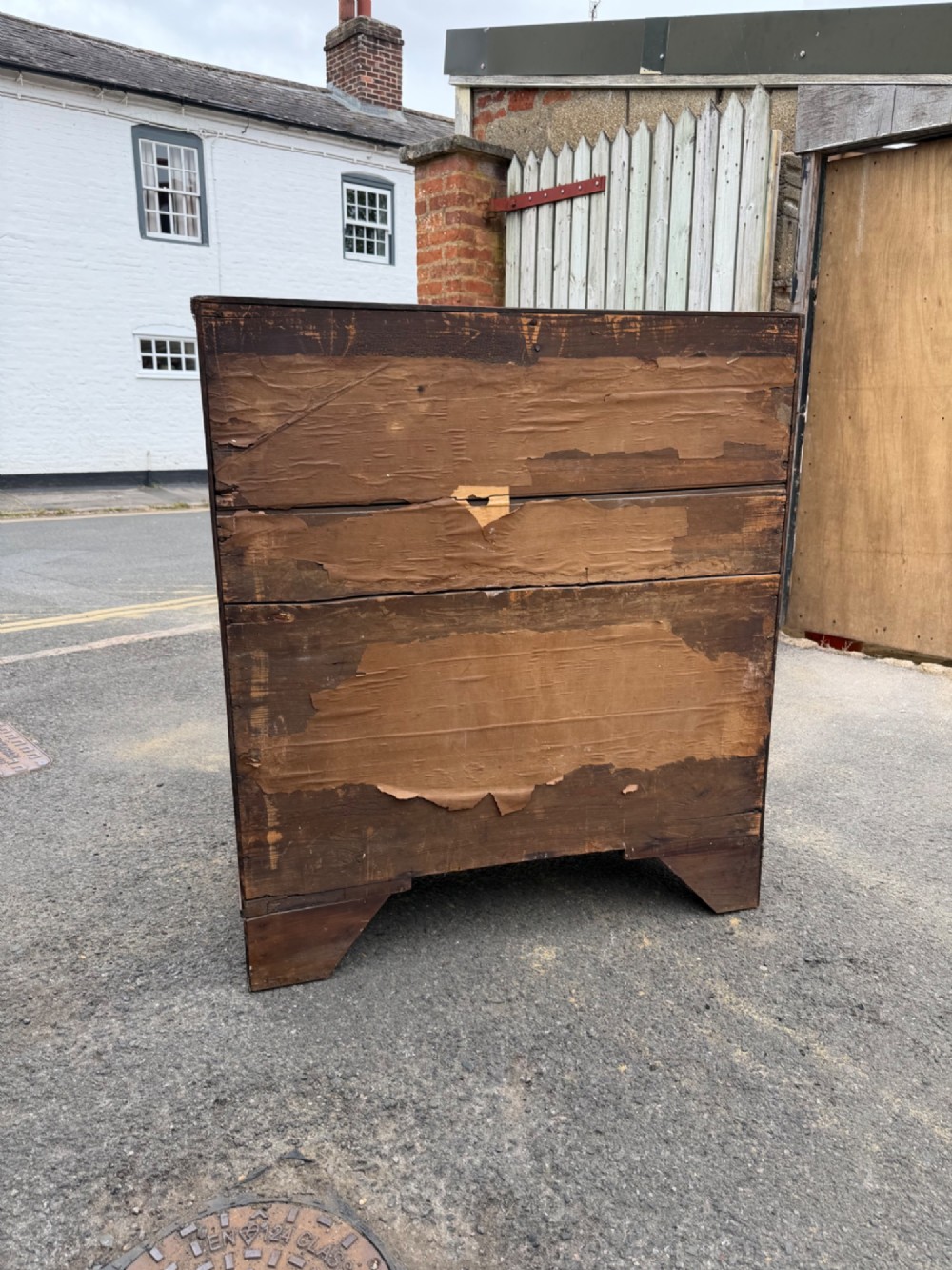 A Georgian oak chest of drawers featuring two short over three long graduated drawers with brass oval handles and bracket feet. View II