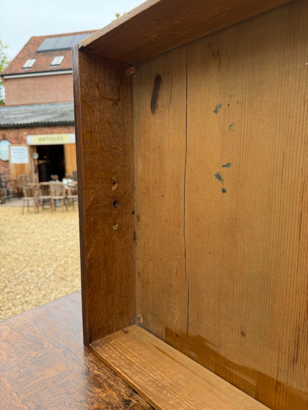 A Georgian oak chest of drawers featuring two short over three long graduated drawers with brass oval handles and bracket feet. View V