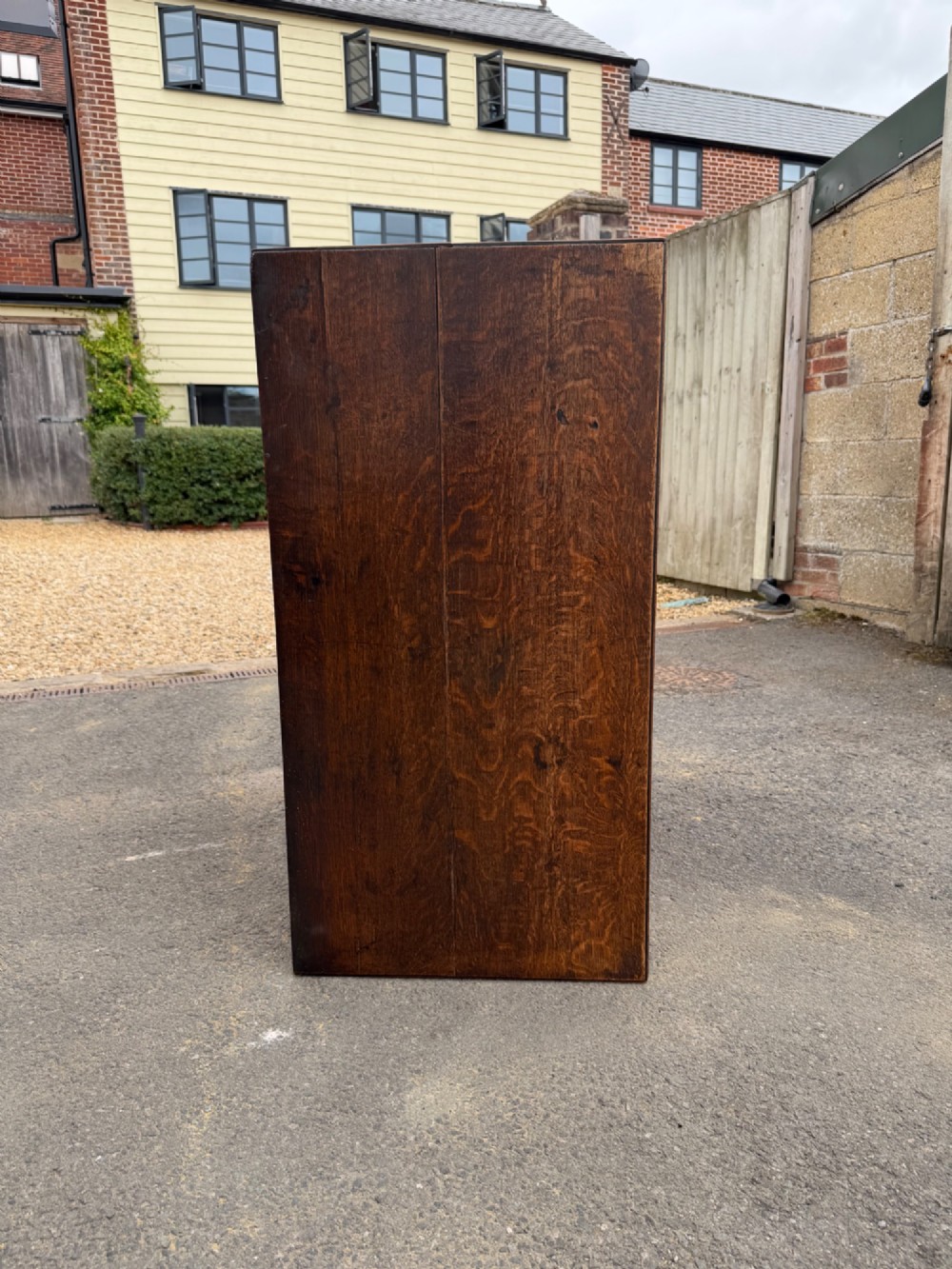 A Georgian oak chest of drawers featuring two short over three long graduated drawers with brass oval handles and bracket feet. View IX