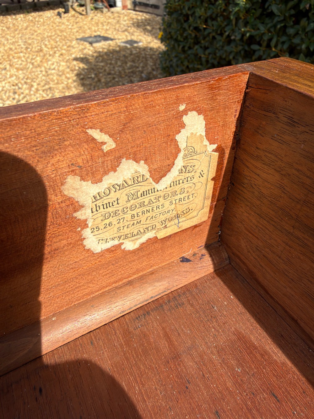 An antique walnut writing desk with a green leather inset top, brass drawer pulls, turned legs on castors, and built-in drawer pedestals. View III