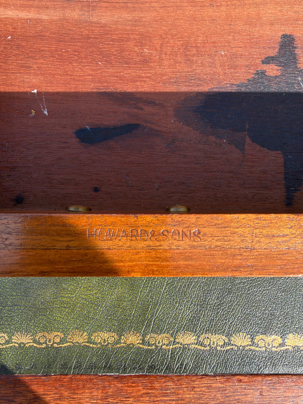 An antique walnut writing desk with a green leather inset top, brass drawer pulls, turned legs on castors, and built-in drawer pedestals. View IV
