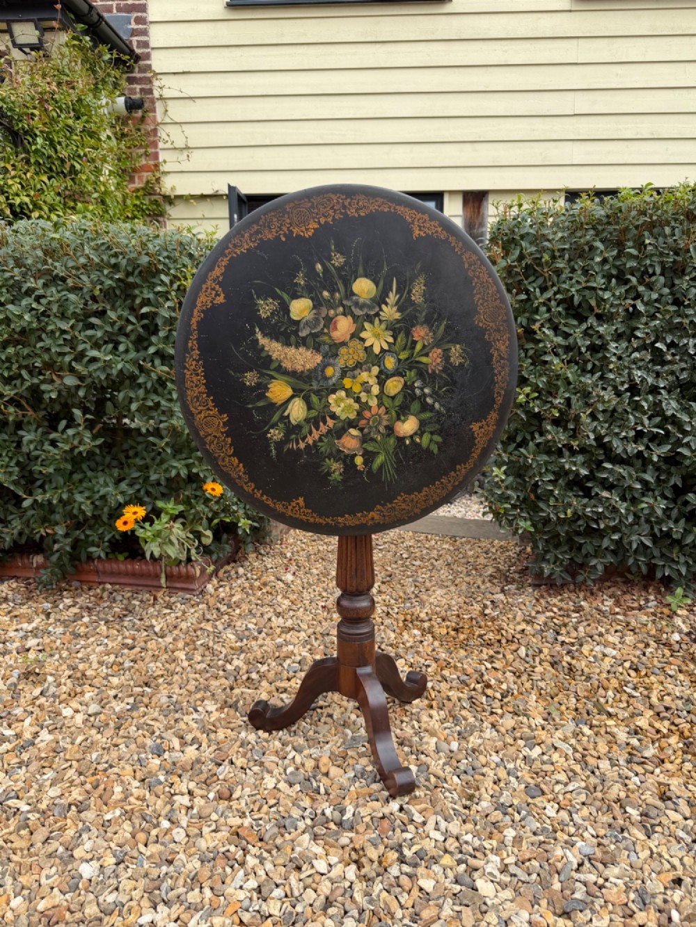 A nineteenth-century circular side table featuring a black slate top decorated with hand-painted botanical flowers and a gilt border, raised on a fluted dark wood pedestal stem with tripod legs. View V