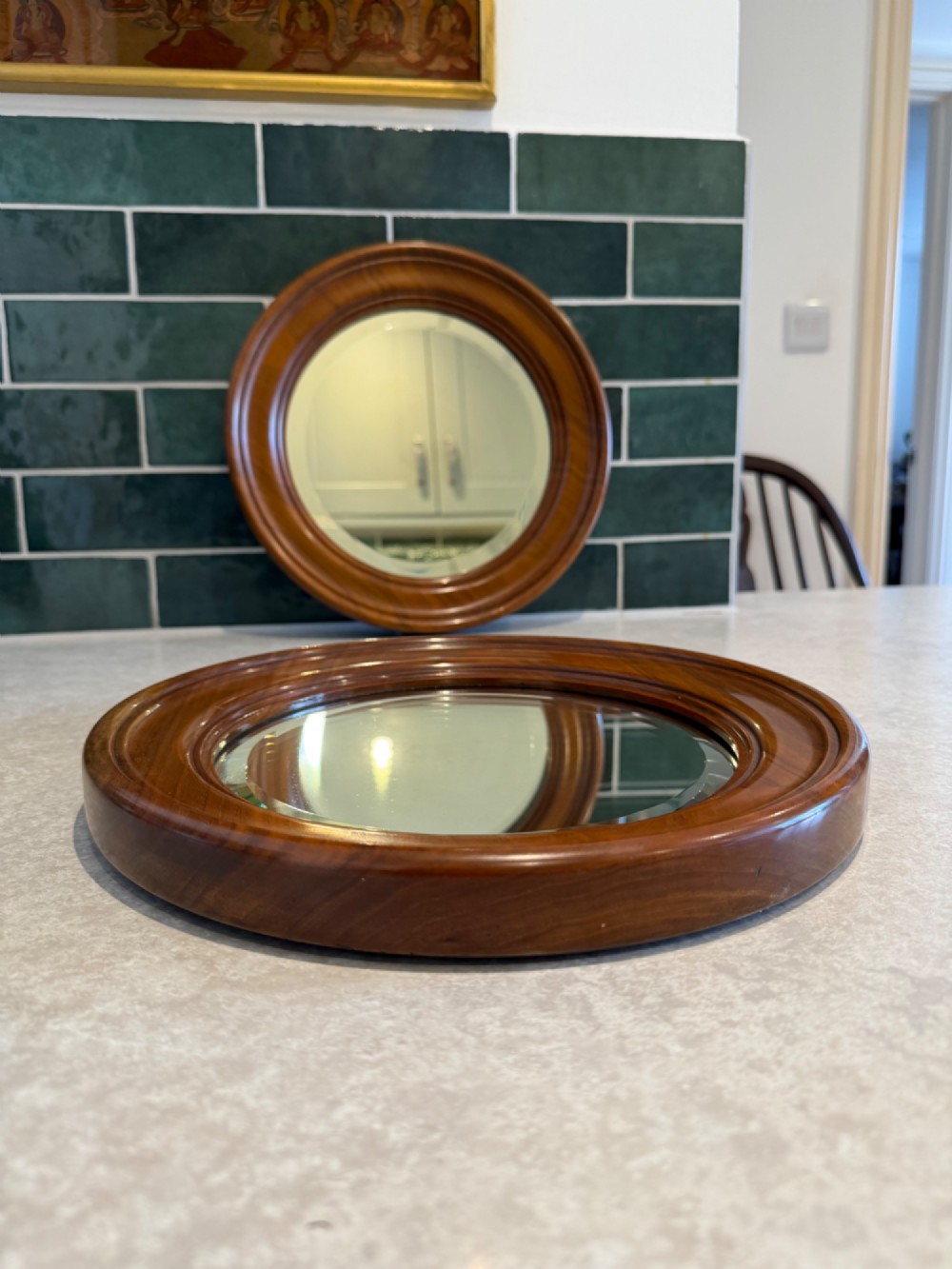 A pair of circular mirrors set in deep moulded warm brown walnut wood frames. View II