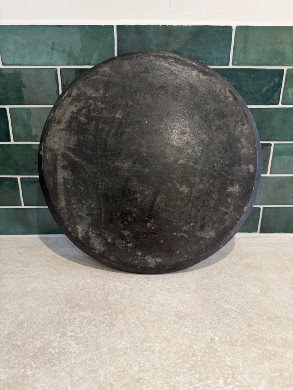 A circular black papier-mache tray hand-painted with equestrian riders in orange, green, and gold against a dark background. View IV