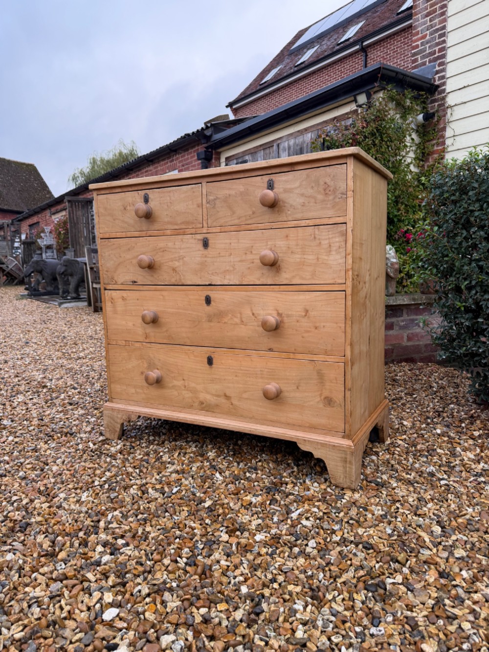 A nineteenth-century light maple chest of drawers featuring a two-over-three drawer arrangement, turned wooden handles, and bracket feet.