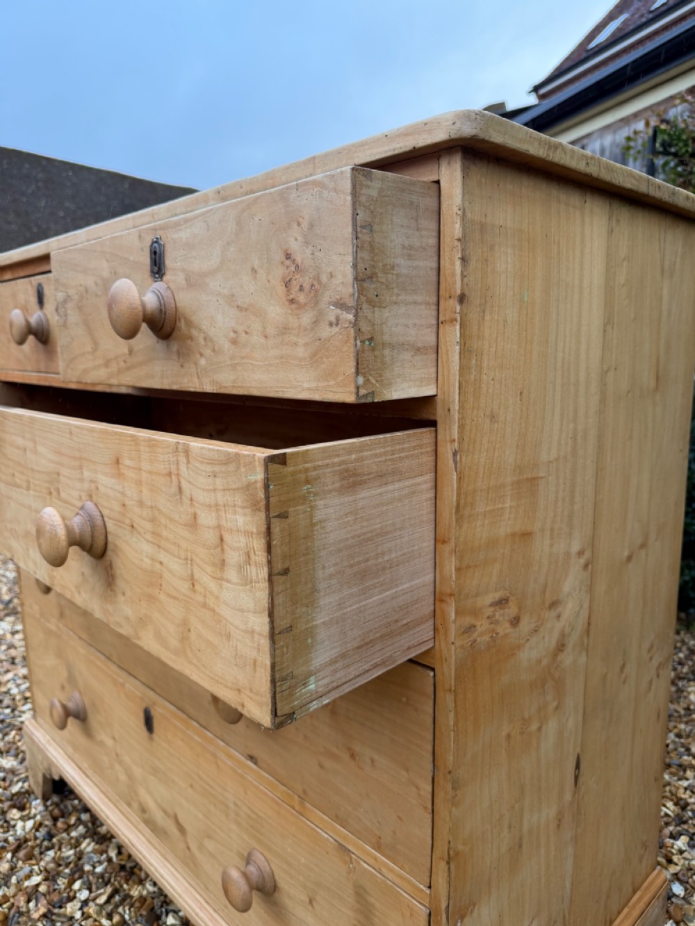 A nineteenth-century light maple chest of drawers featuring a two-over-three drawer arrangement, turned wooden handles, and bracket feet. View III