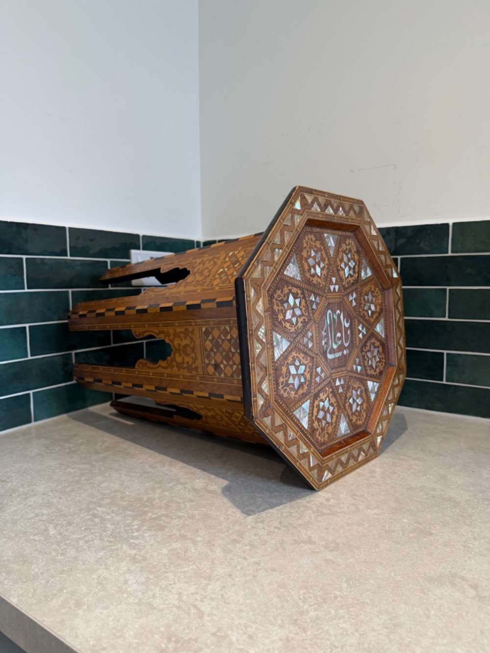 An octagonal wooden side table with intricate Moorish geometric marquetry, mother-of-pearl inlay, and Arabic calligraphy in the central medallion. View IV