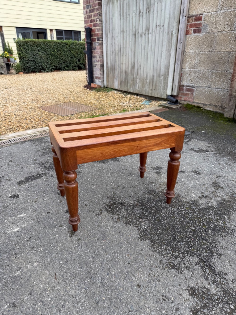 A Victorian warm brown timber luggage rack featuring a slatted wooden top supported by four turned legs.