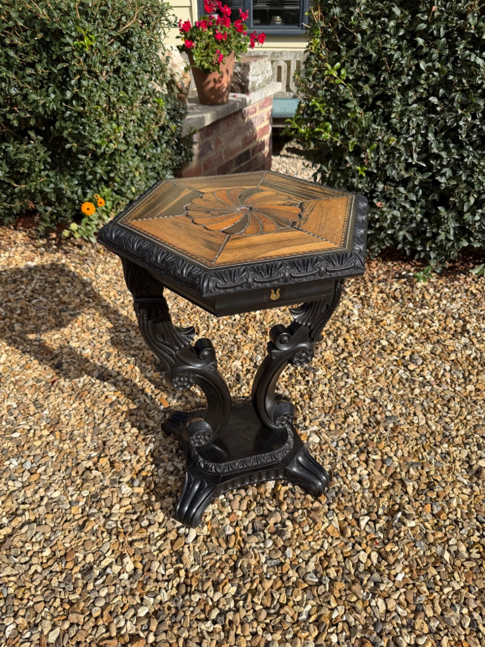 A pair of 19th-century Ceylonese ebony hexagonal occasional tables featuring inlaid geometric specimen wood tops and carved scroll legs. View II