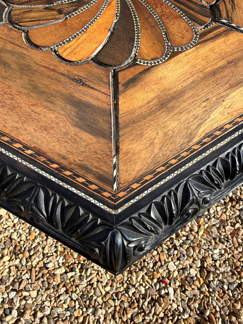 A pair of 19th-century Ceylonese ebony hexagonal occasional tables featuring inlaid geometric specimen wood tops and carved scroll legs. View VII