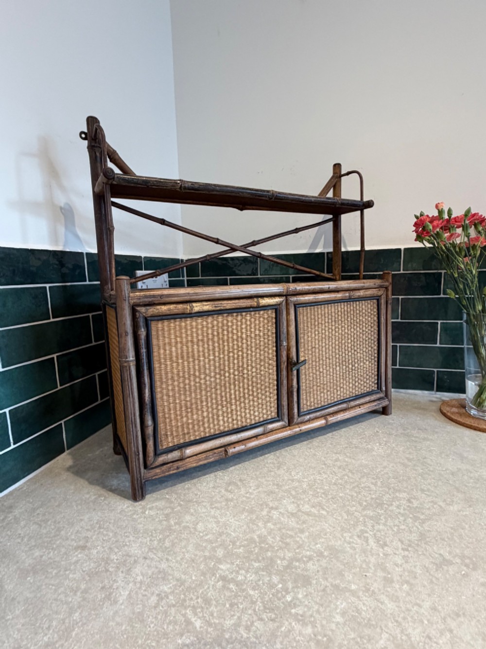 A Victorian bamboo and woven cane wall cupboard featuring two lower cabinet doors, an open upper display shelf, and an X-shaped cross support.