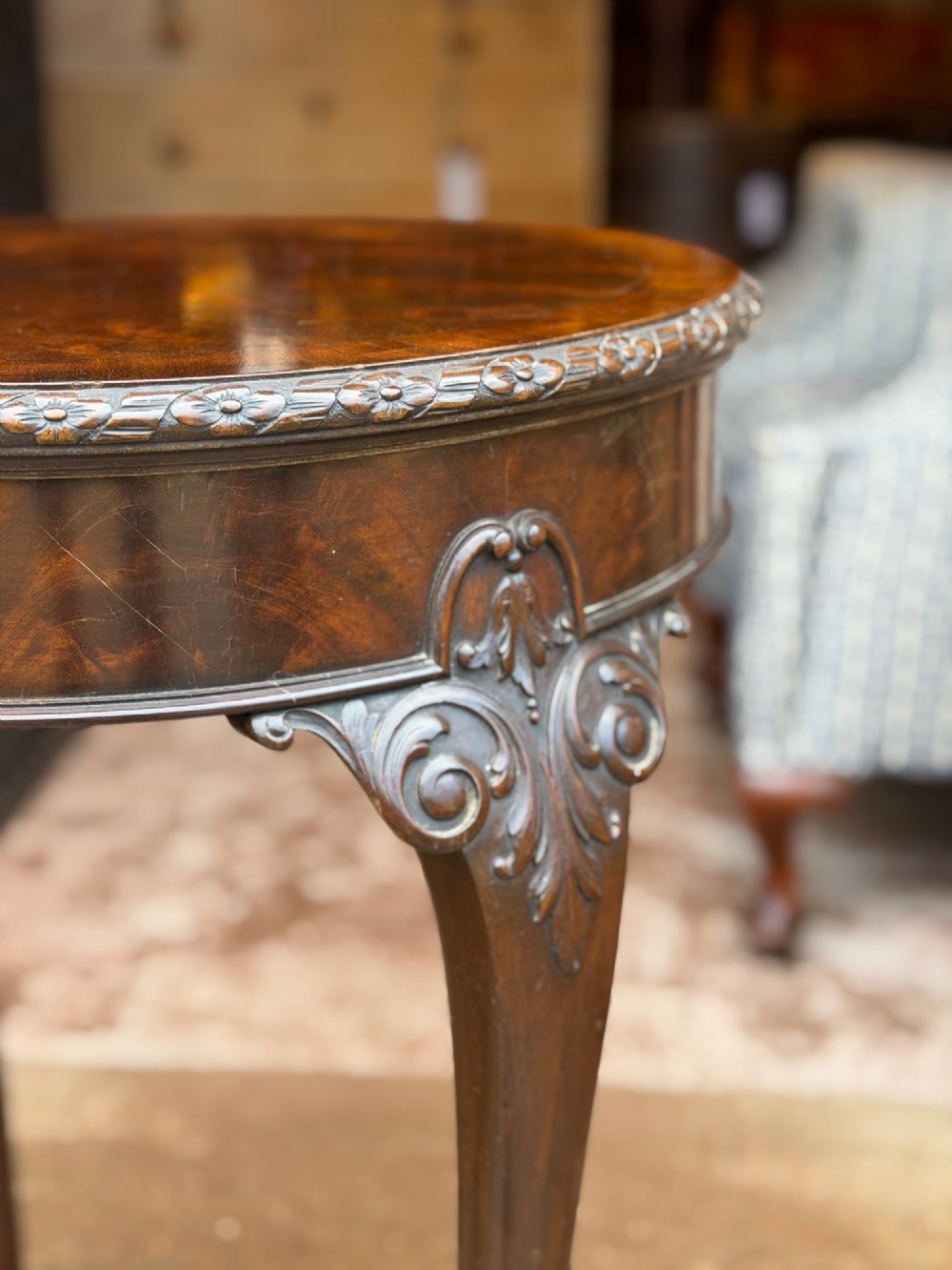 A circular mahogany occasional table featuring carved cabriole legs with pad feet and detailed knee carvings. View IV