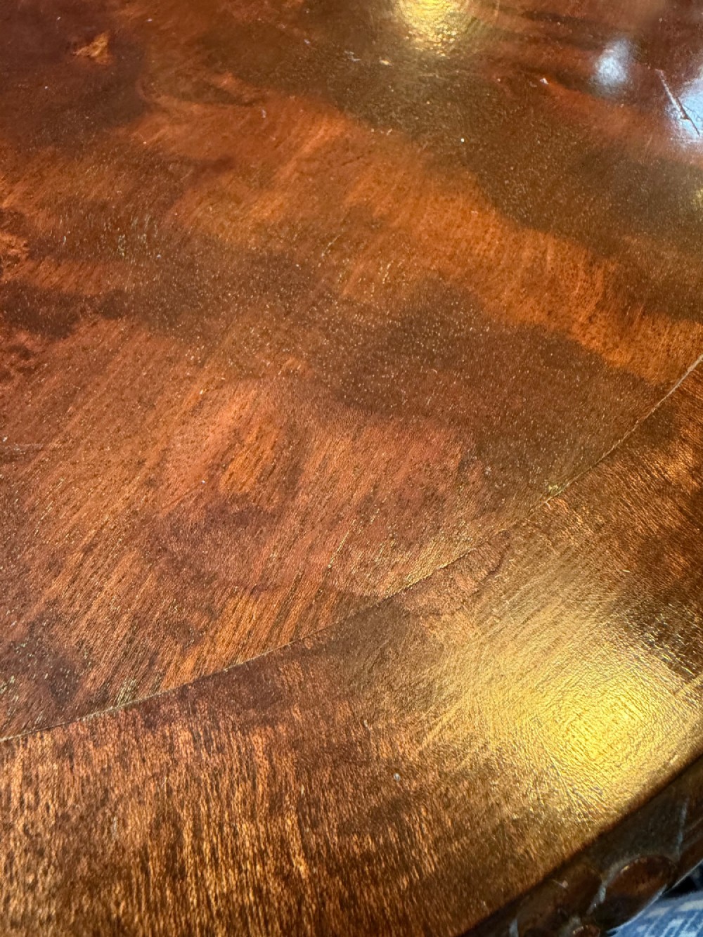 A circular mahogany occasional table featuring carved cabriole legs with pad feet and detailed knee carvings. View V