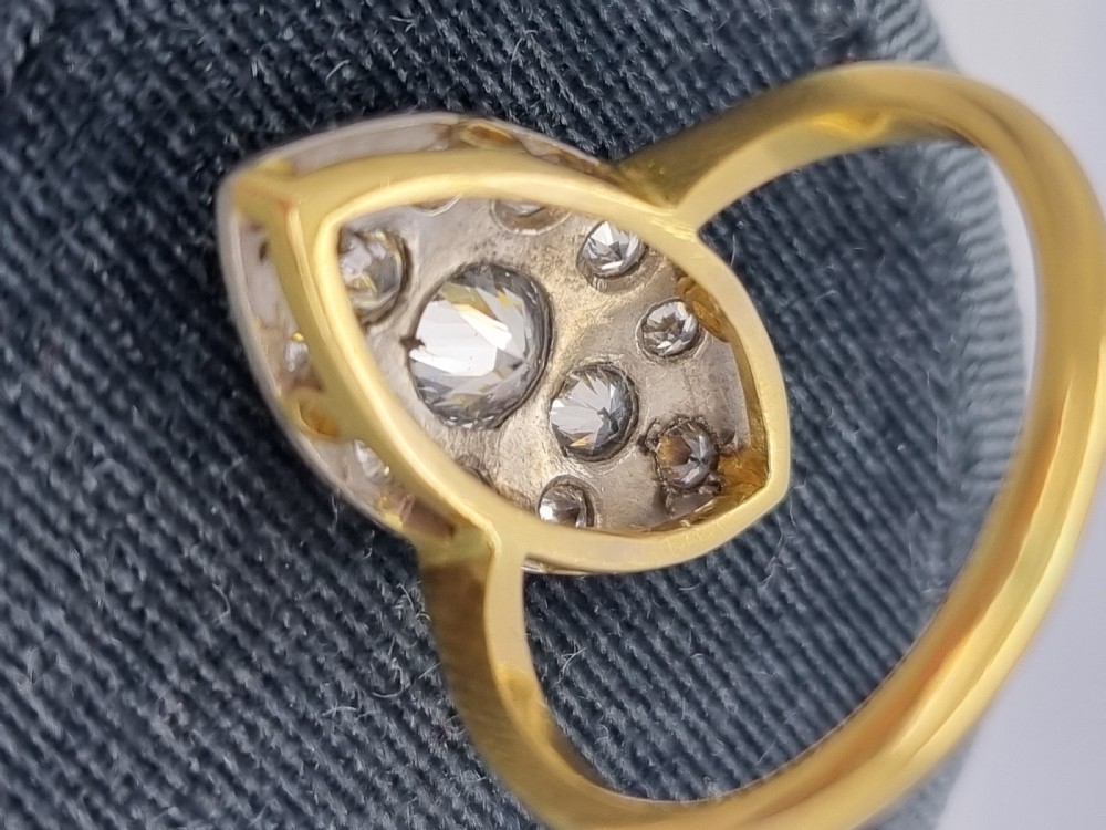 An antique navette-shaped cluster ring crafted in yellow gold with a platinum setting face set with multiple diamonds. View IV