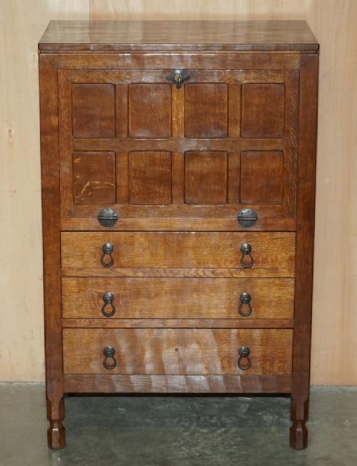 fig 3. A solid oak fall-front bureau desk featuring three lower drawers, panelled sides, and hand-forged wrought iron drop handles.