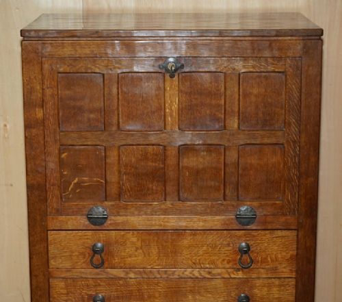 fig 4. A solid oak fall-front bureau desk featuring three lower drawers, panelled sides, and hand-forged wrought iron drop handles.