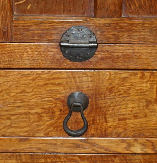 fig 5. A solid oak fall-front bureau desk featuring three lower drawers, panelled sides, and hand-forged wrought iron drop handles.