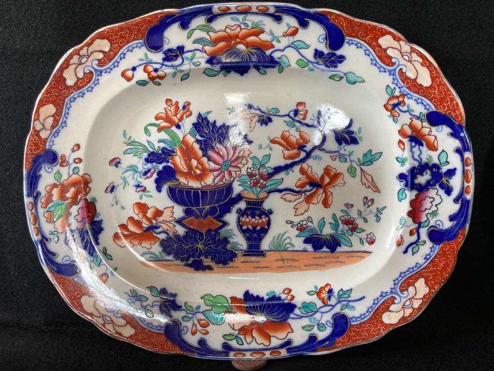 A pair of matching Victorian oval ironstone platters decorated with Imari style floral motifs in cobalt blue, terracotta, and gold detailing. View II