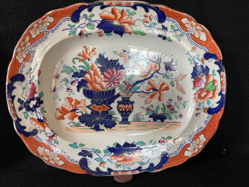 A pair of matching Victorian oval ironstone platters decorated with Imari style floral motifs in cobalt blue, terracotta, and gold detailing. View III