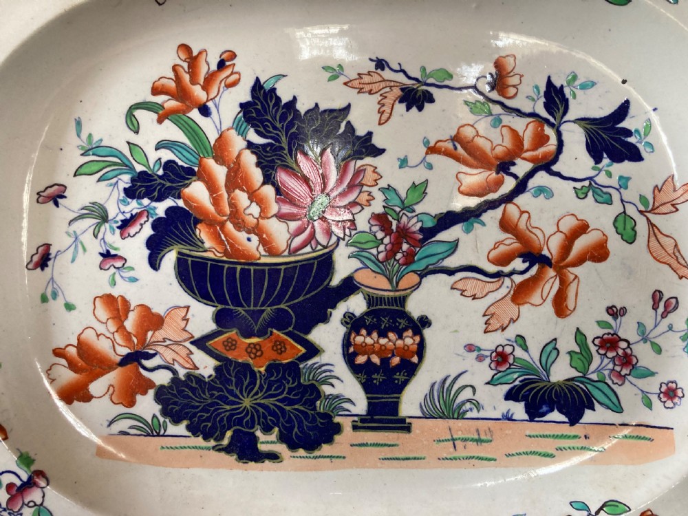 A pair of matching Victorian oval ironstone platters decorated with Imari style floral motifs in cobalt blue, terracotta, and gold detailing. View V