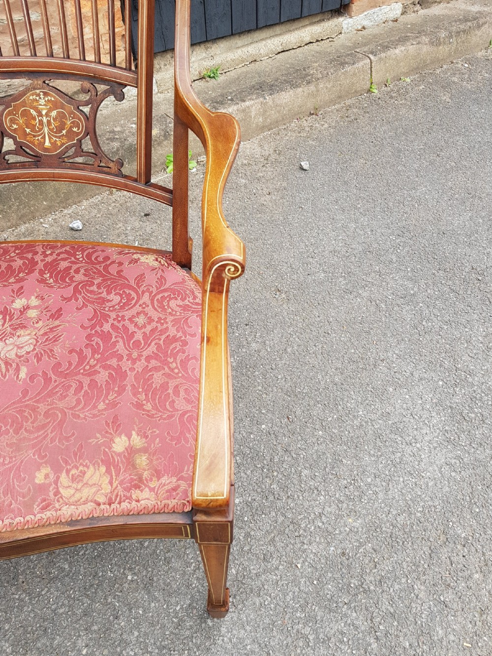 An Edwardian mahogany open armchair featuring floral marquetry inlay on the crest rail and central splat, swept armrests, and pink damask fabric upholstery. View IV