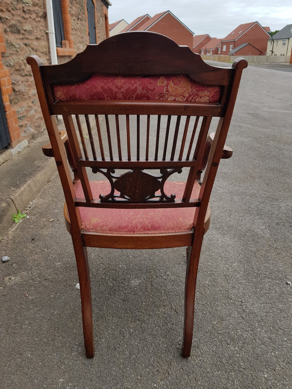An Edwardian mahogany open armchair featuring floral marquetry inlay on the crest rail and central splat, swept armrests, and pink damask fabric upholstery. View VI