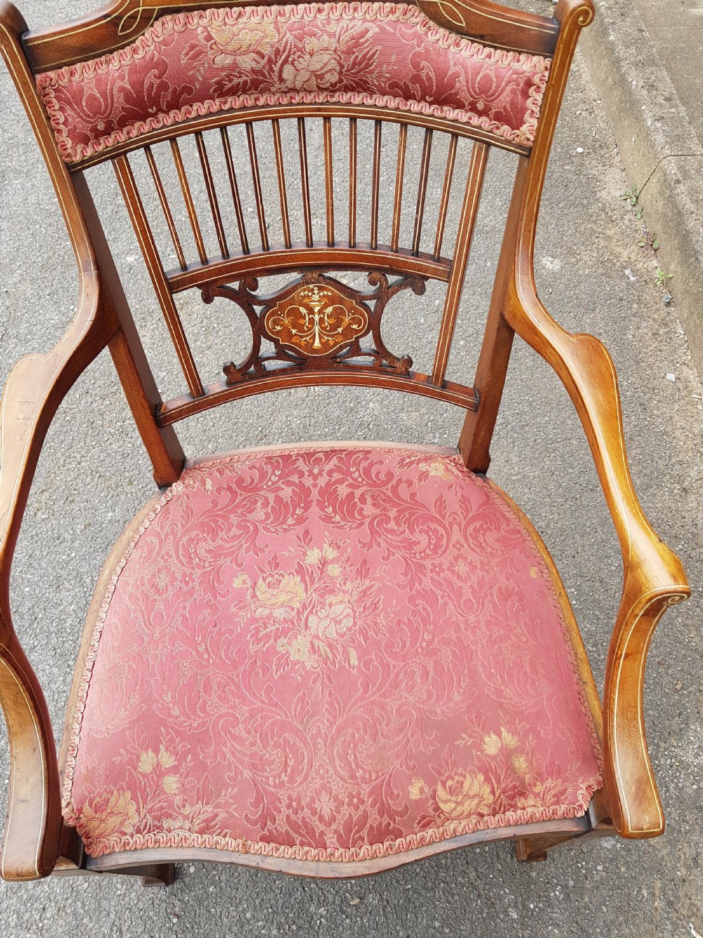 An Edwardian mahogany open armchair featuring floral marquetry inlay on the crest rail and central splat, swept armrests, and pink damask fabric upholstery. View VII