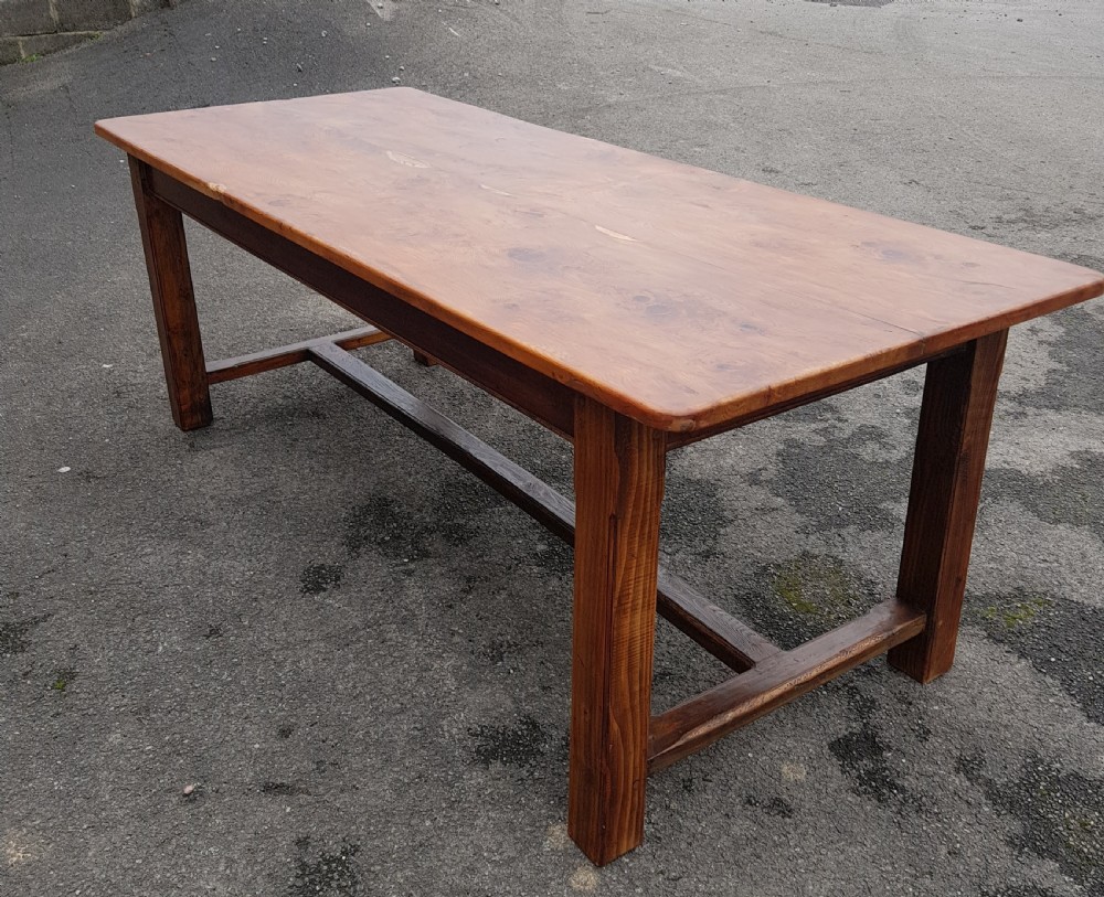 A rectangular yew wood farmhouse dining table featuring a polished timber tabletop, square legs, and an H-stretcher base. View II