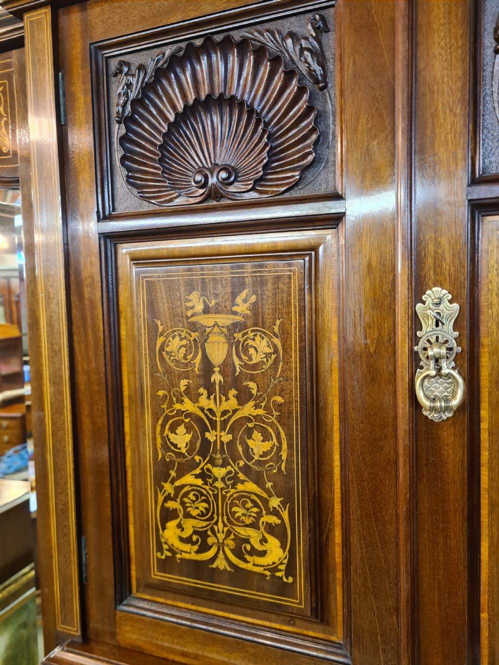 An Edwardian mahogany breakfront wardrobe with a central carved section, drawers, an open recessed shelf, and two full-length mirrored side doors. View VIII