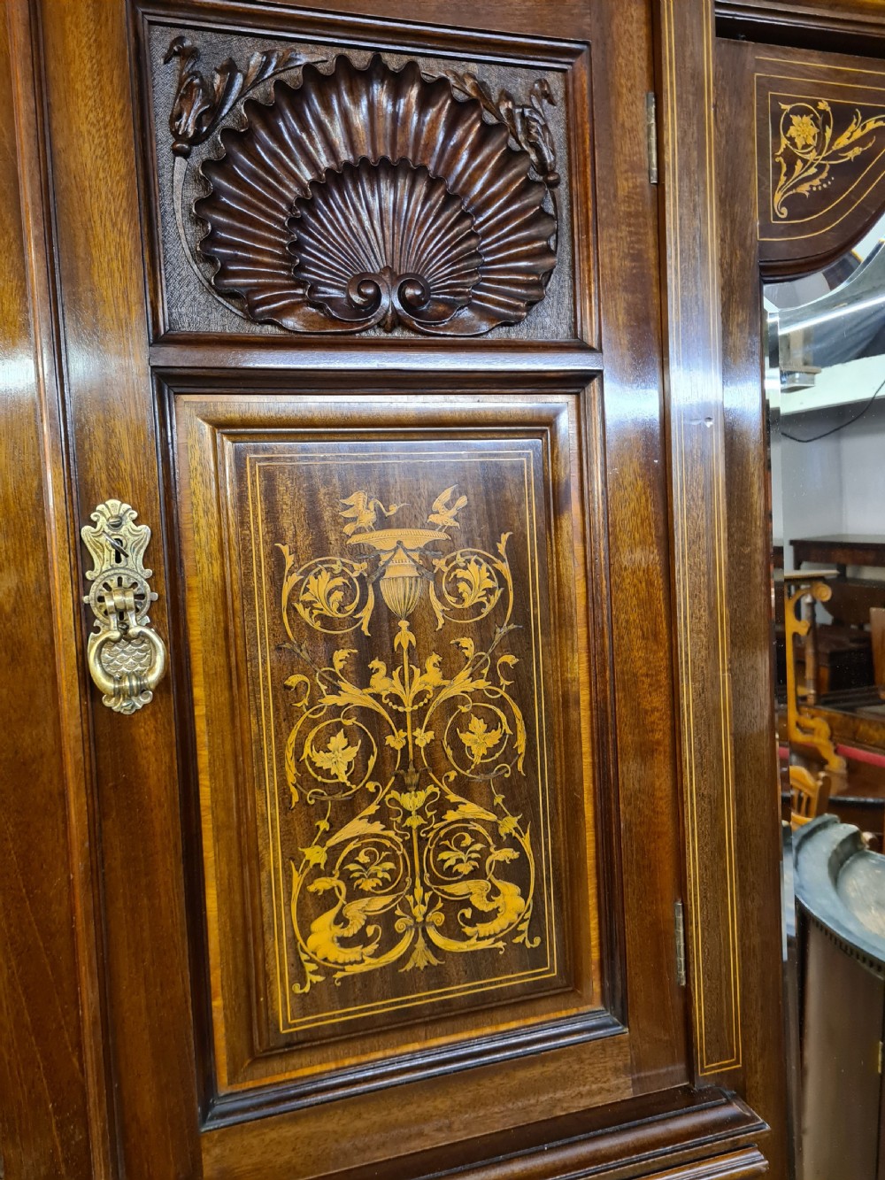 An Edwardian mahogany breakfront wardrobe with a central carved section, drawers, an open recessed shelf, and two full-length mirrored side doors. View IX