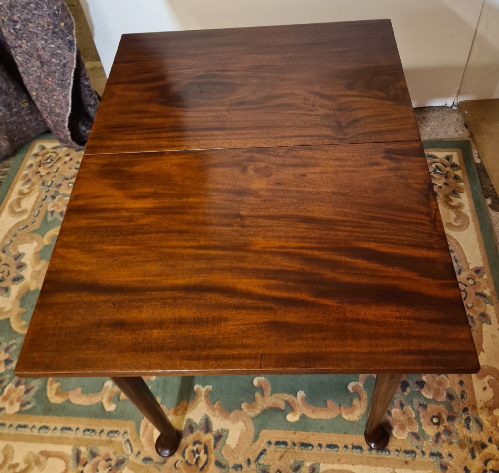 A Georgian mahogany side table featuring a polished rectangular top with a single hinged drop-leaf extension supported on turned legs.