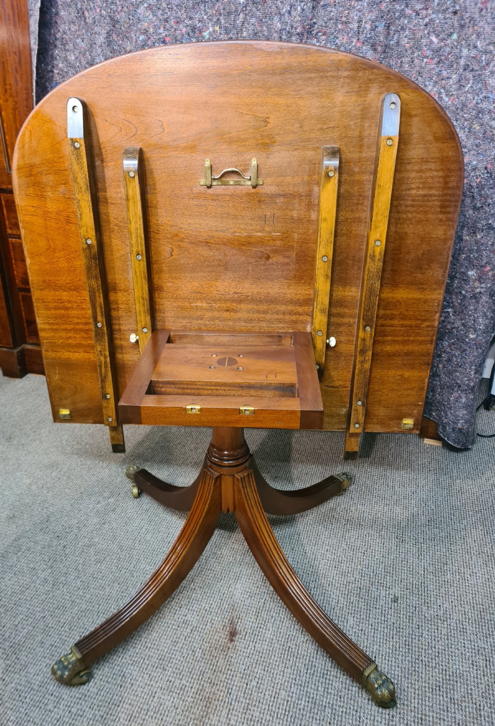 A polished warm brown mahogany dining table featuring fine brass inlay stringing around the perimeter with an inserted central leaf. View VII