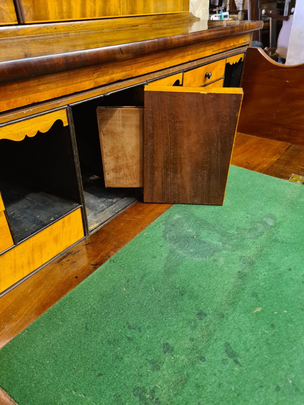 A nineteenth-century mahogany secretaire bookcase featuring an upper cabinet with twin astragal glazed doors above a lower chest with three drawer fronts set on turned feet. View V