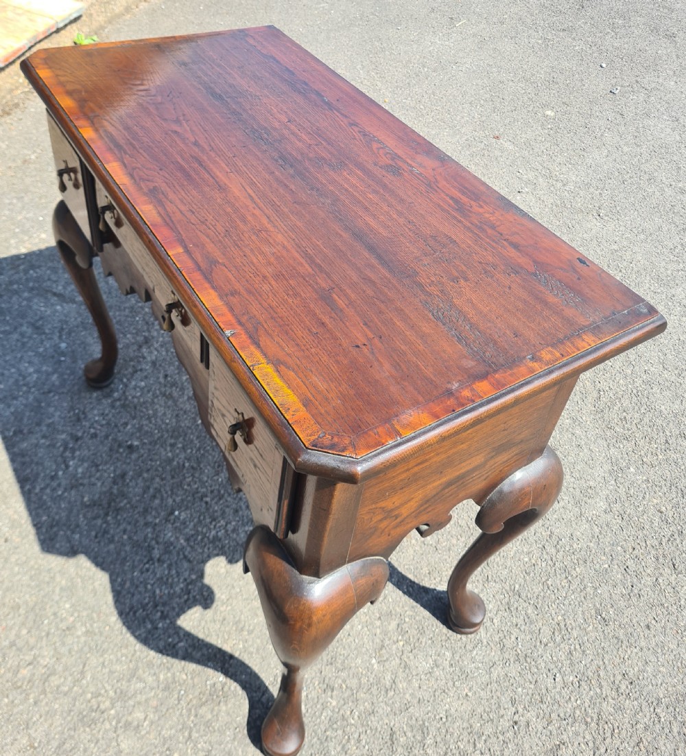A 1920s Georgian style oak lowboy featuring three drawers with brass drop handles, a shaped lower apron, and four cabriole legs ending in pad feet. View III