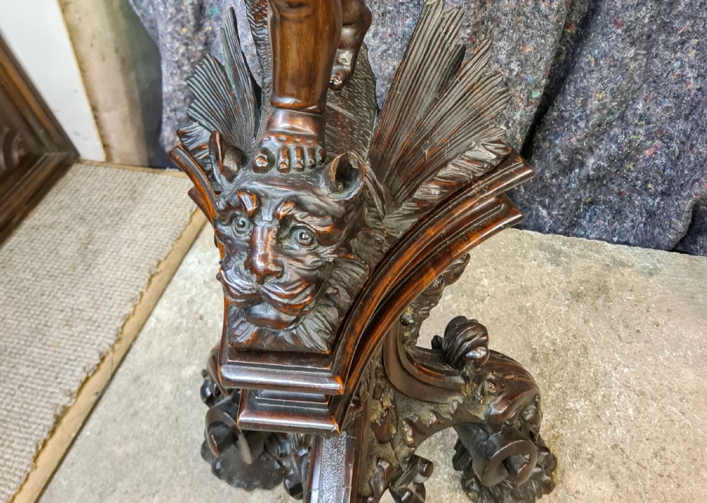 A 19th-century carved dark lime wood sculpture of a putto holding a shell basin aloft, standing on an ornate scroll-carved pedestal. View IX