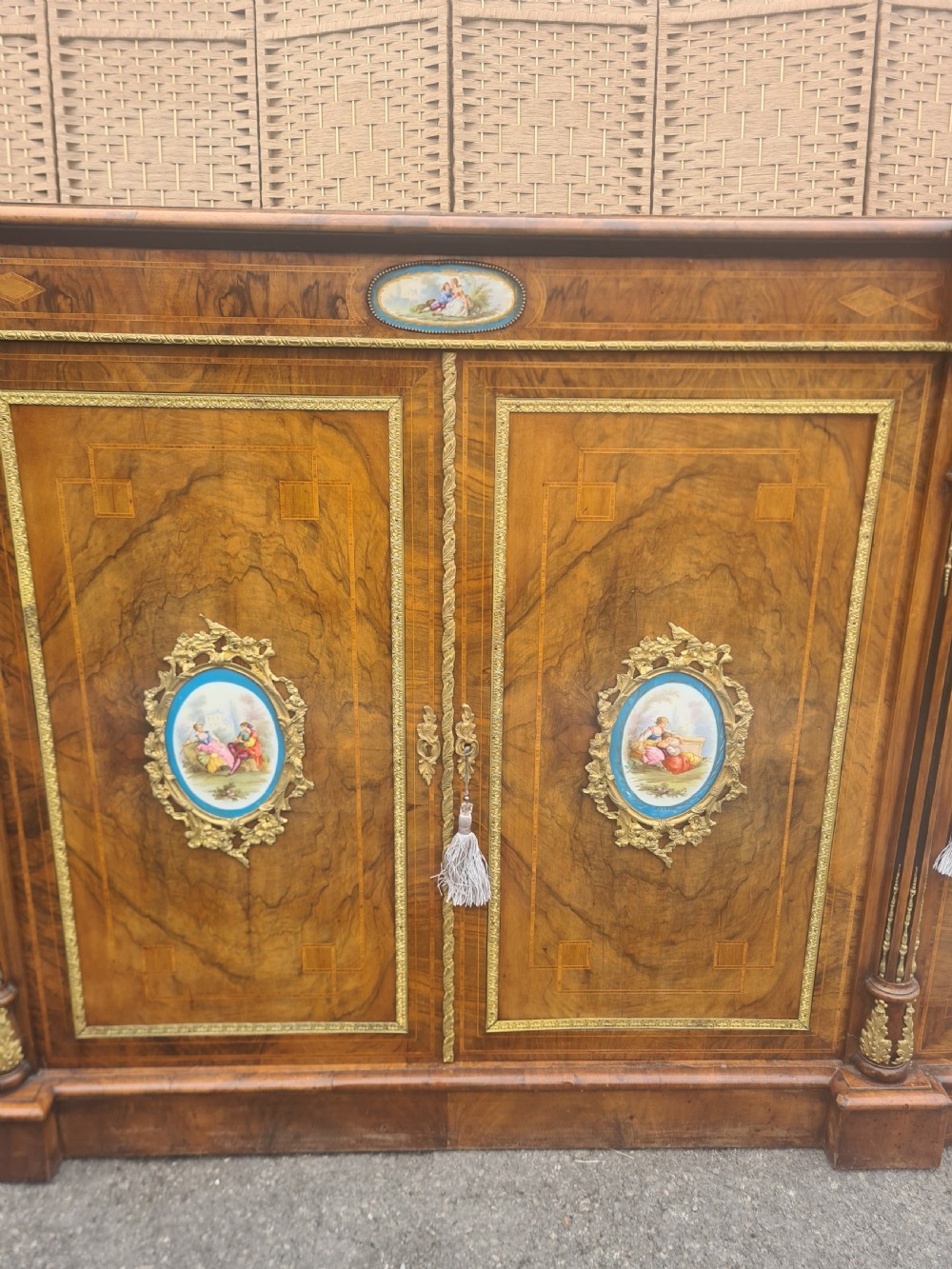 A Victorian burr walnut credenza with central timber doors framed in ormolu, featuring oval Sevres-style porcelain plaques and curved glass display cabinets on each side. View III