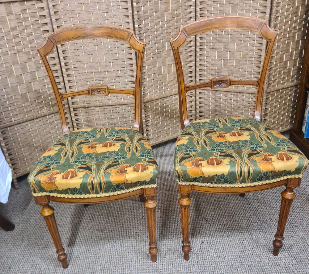 A pair of 19th-century satinwood side chairs featuring inlaid frames, open backs, turned fluted legs, and green floral pattern upholstery. View II