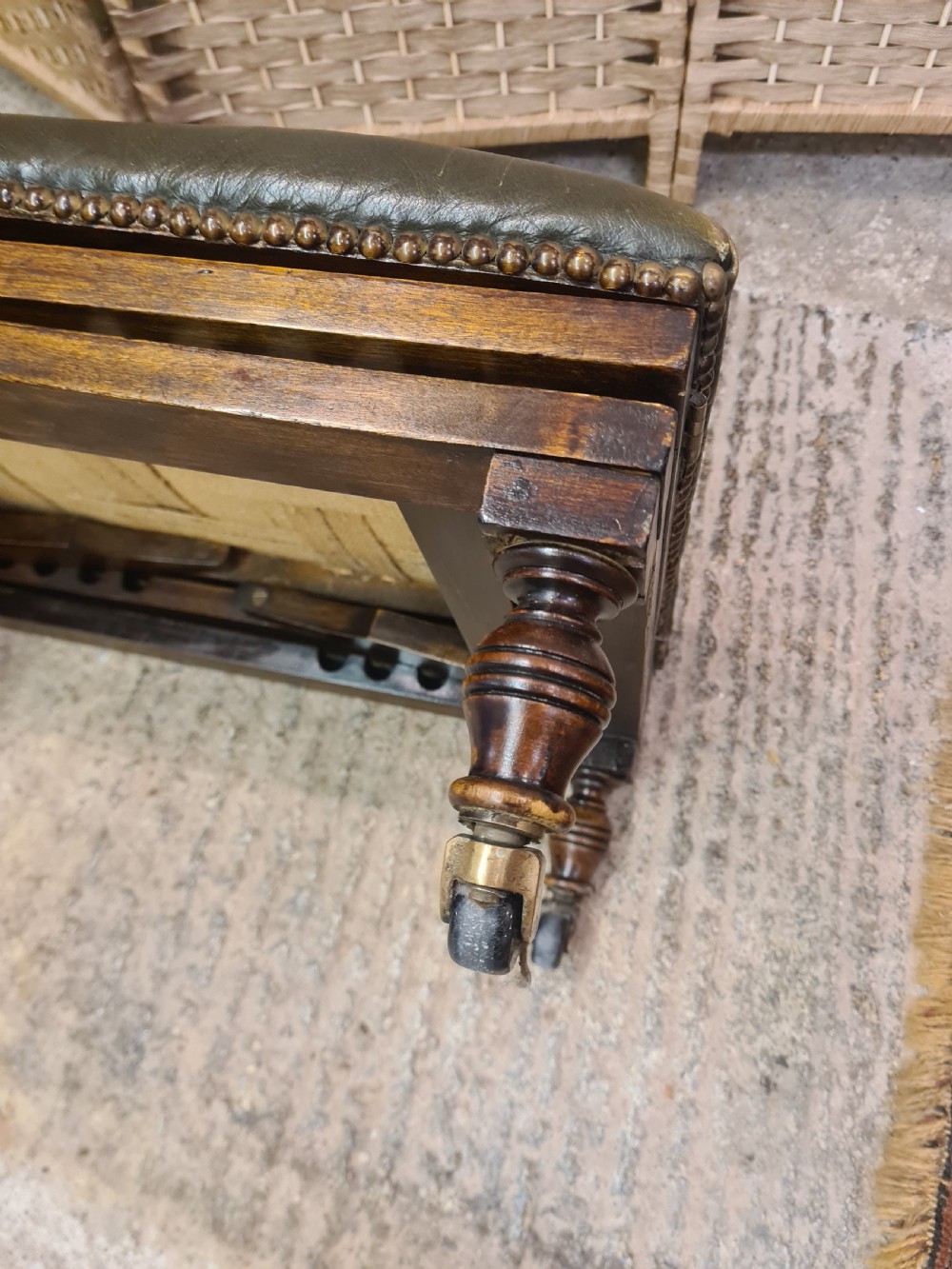 An Edwardian metamorphic gout stool crafted from dark mahogany with green leather upholstery, brass stud detailing, and a notched ratchet adjustment mechanism. View III