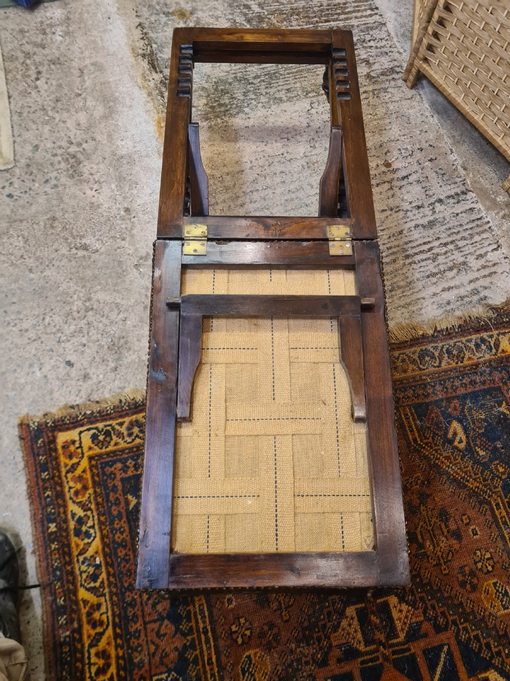 An Edwardian metamorphic gout stool crafted from dark mahogany with green leather upholstery, brass stud detailing, and a notched ratchet adjustment mechanism. View VII
